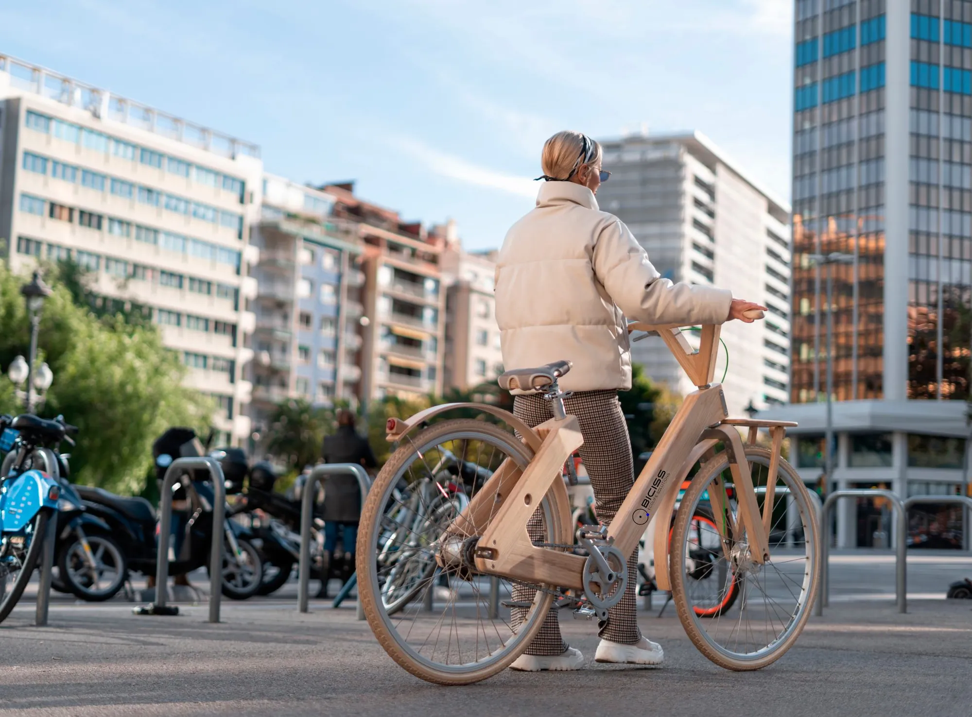 Mujer con una bicicleta eléctrica en una calle de la ciudad